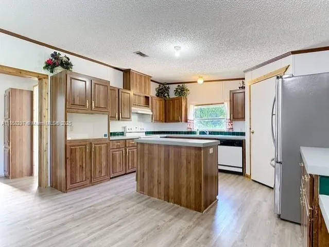 a kitchen with stainless steel appliances granite countertop a refrigerator and a sink
