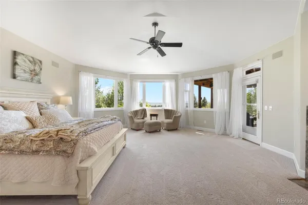 a spacious bedroom with a bed couch and window