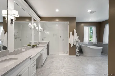 a bathroom with a granite countertop sink a toilet a large mirror and a bathtub