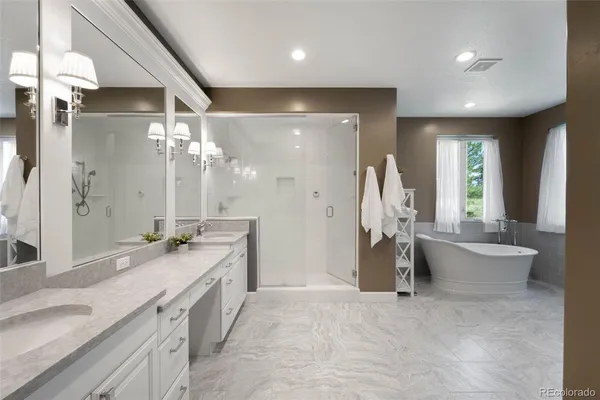 a bathroom with a granite countertop sink a toilet a large mirror and a bathtub