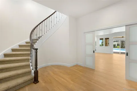 a view of a hallway with wooden floor and entryway