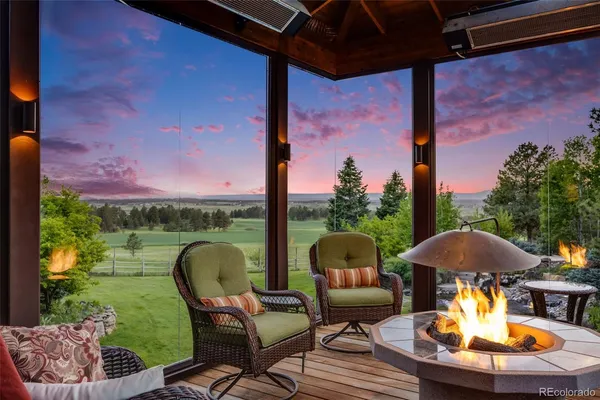 a patio with table and chairs and a fire pit