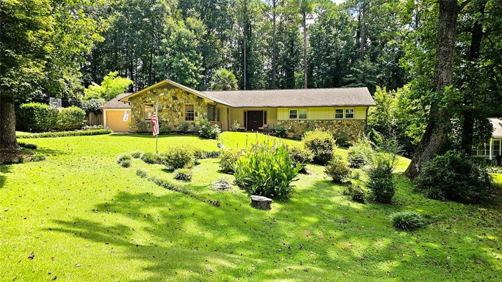 4682 Lucerne Valley Road Southwest Lilburn, GA 30047 - Photo 1 of 1 a view of a house with a big yard plants and large tree