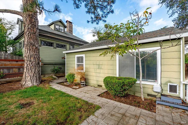 a view of a chair and table in backyard of the house