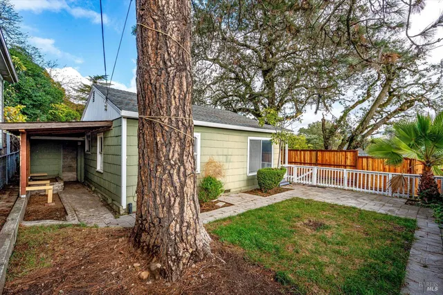 a view of a house with backyard and a tree