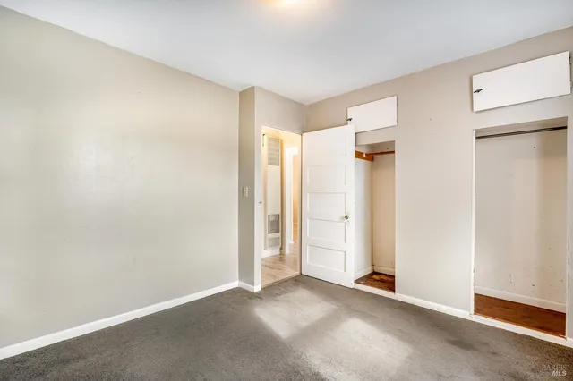 an empty room with closet and a window