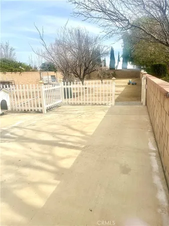a view of a swimming pool with a yard and wooden fence