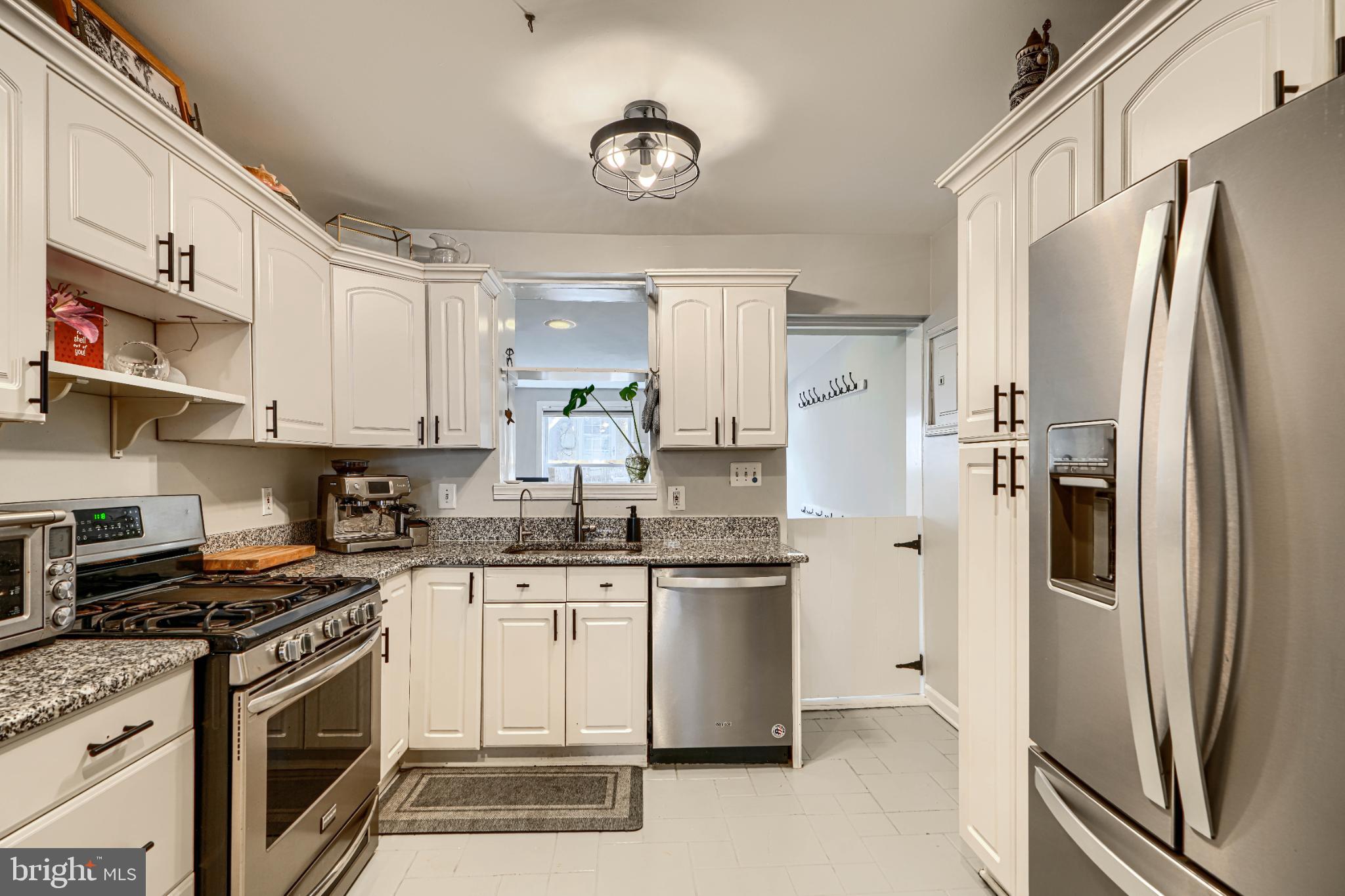 438 East Clement Street Baltimore, MD 21230 - Photo 15 of 47 a kitchen with stainless steel appliances granite countertop a stove a refrigerator and a sink