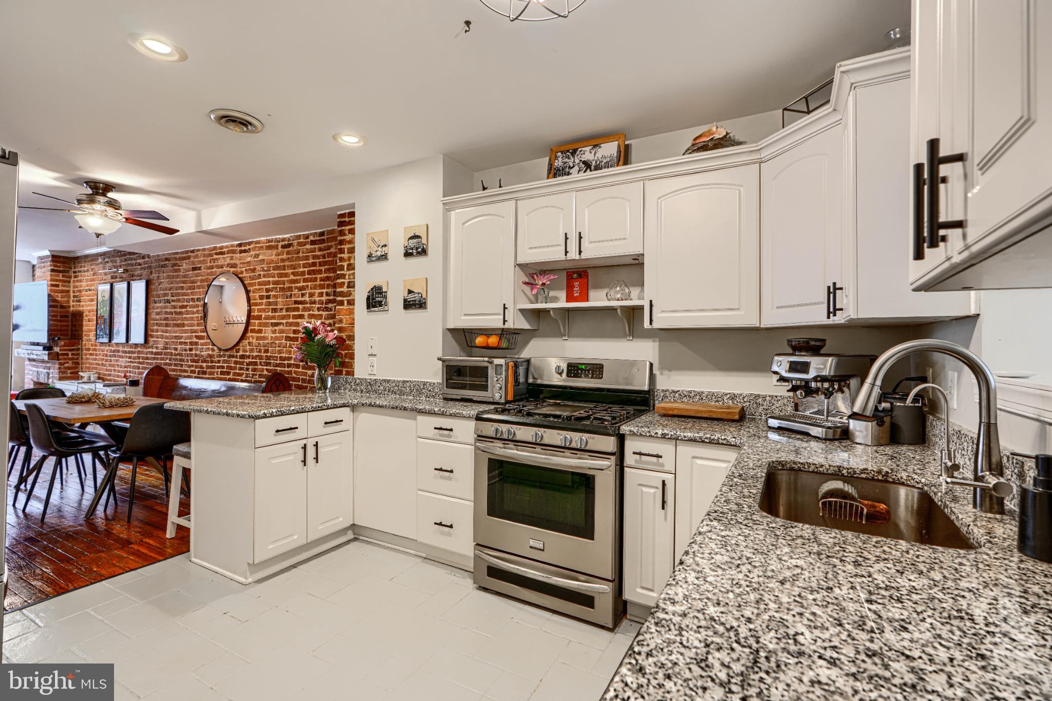 438 East Clement Street Baltimore, MD 21230 - Photo 20 of 47 a kitchen with stainless steel appliances granite countertop a stove top oven a sink a refrigerator and white cabinets