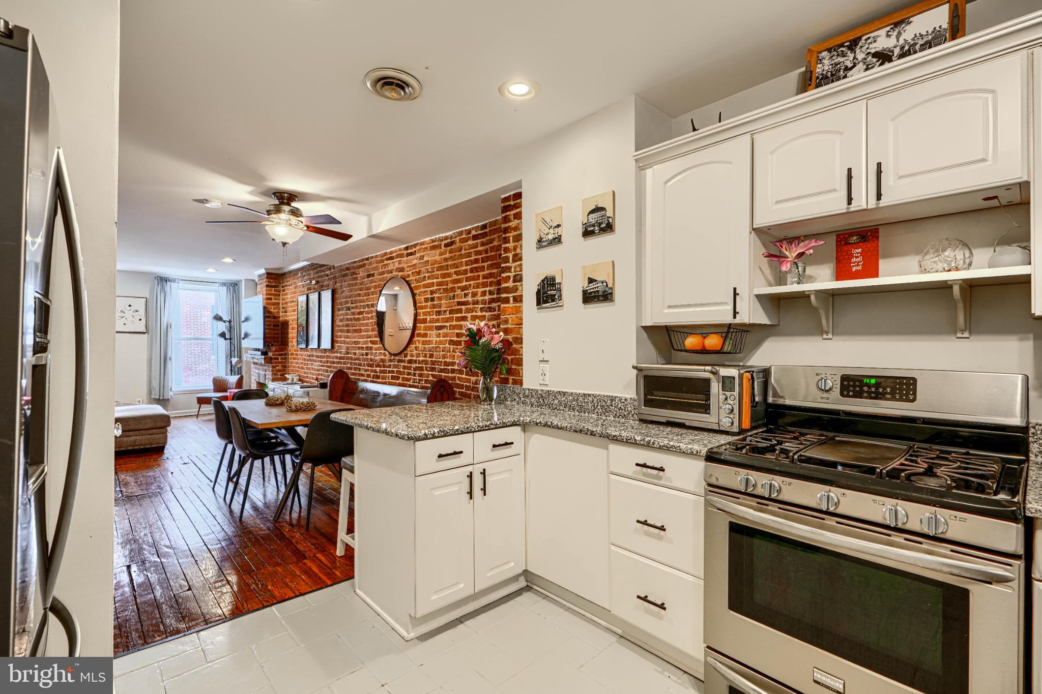 438 East Clement Street Baltimore, MD 21230 - Photo 21 of 47 a kitchen with stainless steel appliances a stove a sink dishwasher and cabinets with wooden floor