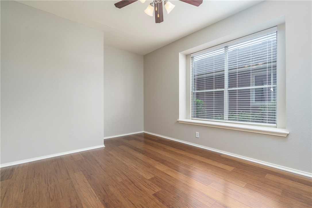 8528 Harrier Drive, Unit 233 Austin, TX 78729 - Photo 13 of 27 a view of an empty room with wooden floor and a window