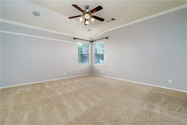 an empty room with windows and fan