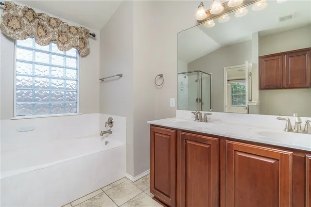 a bathroom with a granite countertop sink mirror and a bathtub