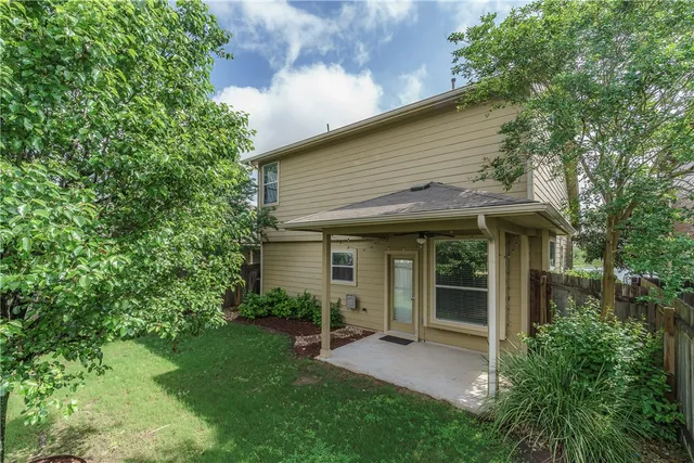 a view of a white house with a big yard and large tree