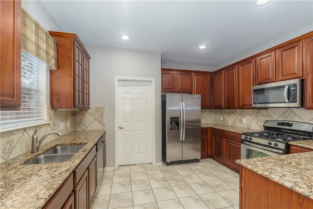 a kitchen with stainless steel appliances granite countertop a sink stove and refrigerator