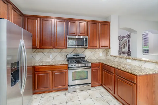 a kitchen with granite countertop stainless steel appliances and wooden cabinets