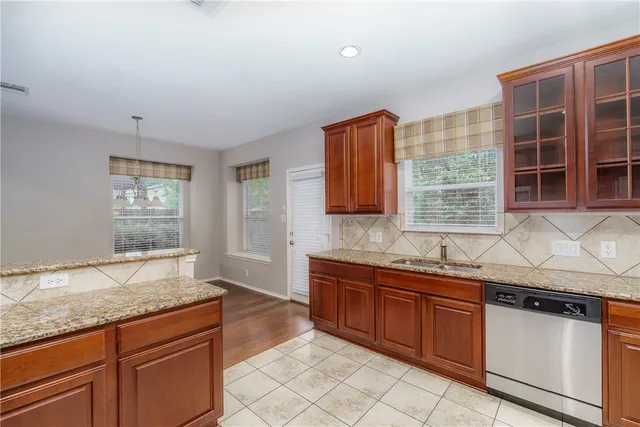 a kitchen with granite countertop a sink and a stove