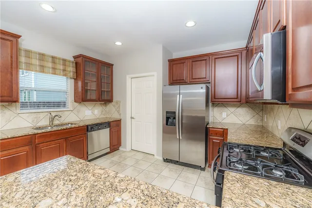 a kitchen with stainless steel appliances granite countertop a sink stove and refrigerator