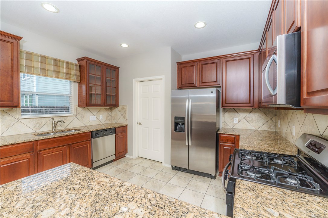 8528 Harrier Drive, Unit 233 Austin, TX 78729 - Photo 7 of 27 a kitchen with stainless steel appliances granite countertop a sink stove and refrigerator