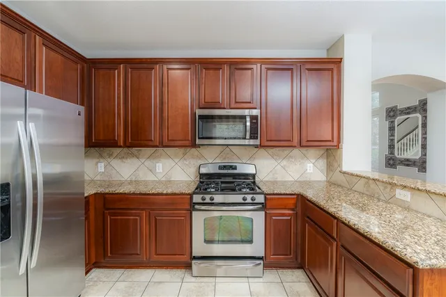 a kitchen with granite countertop a stove top oven microwave and cabinets