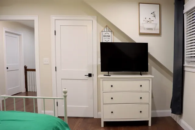 a living room with a flat screen tv a dresser and a flat screen tv