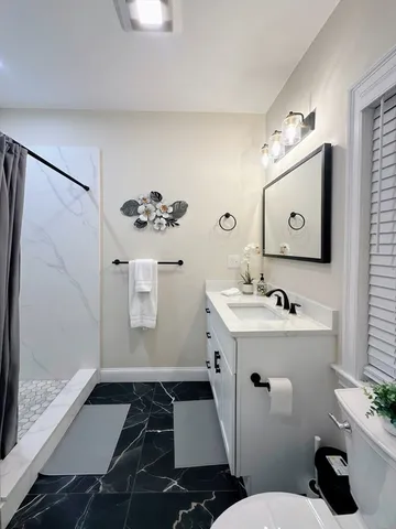 a bathroom with a sink a toilet and shower