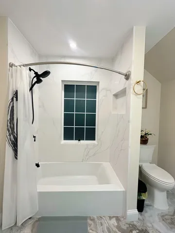 a bathroom with a bathtub a toilet and a shower