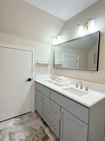 a bathroom with a double vanity sink and a mirror