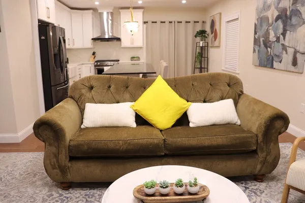 a living room with a couch and a refrigerator