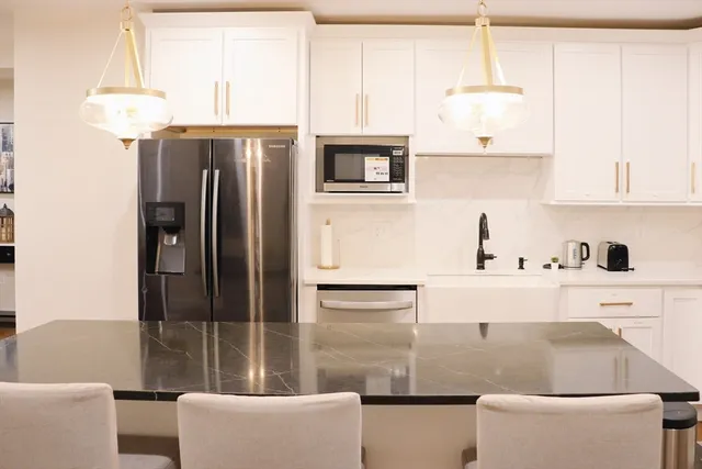 a kitchen with stainless steel appliances granite countertop a refrigerator and a sink