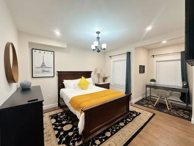 a bedroom with a bed a rug and a dresser