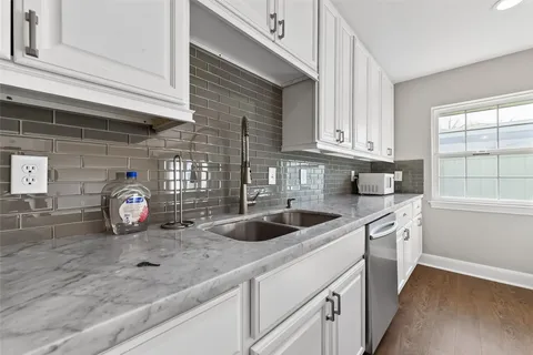 a kitchen with stainless steel appliances granite countertop a sink and a white cabinets