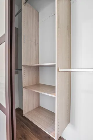 a view of walk in closet with empty racks