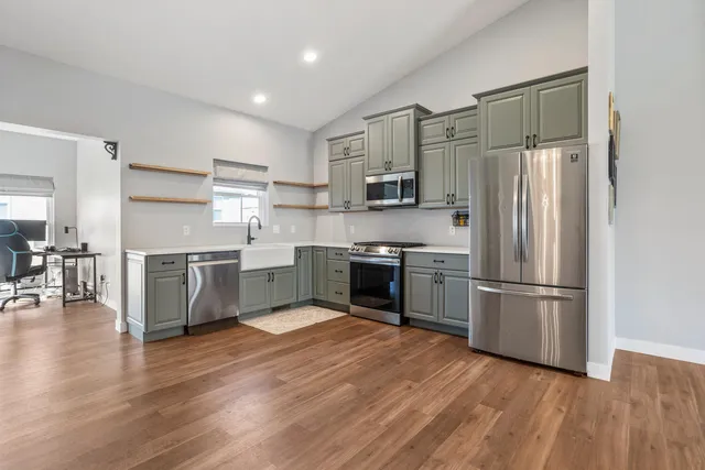 a kitchen with a refrigerator a sink and a stove top oven