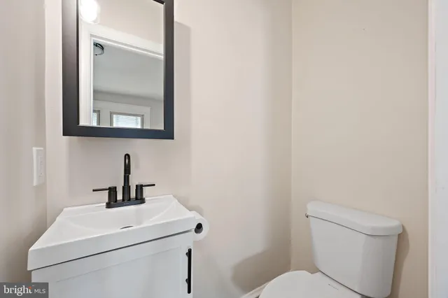 a bathroom with a toilet a sink and mirror