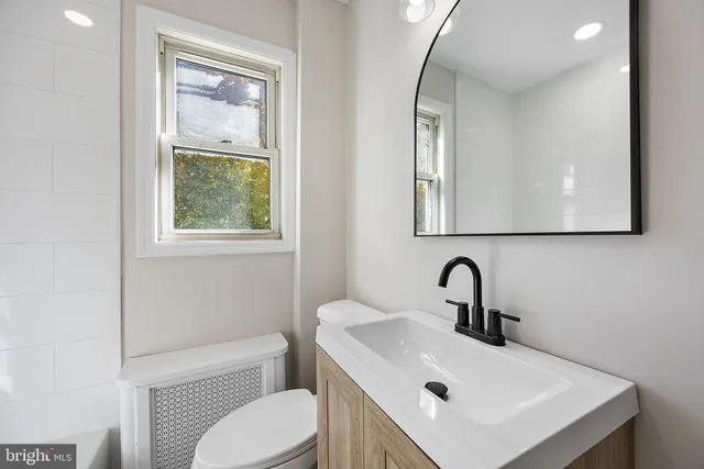 a bathroom with a toilet a sink and mirror