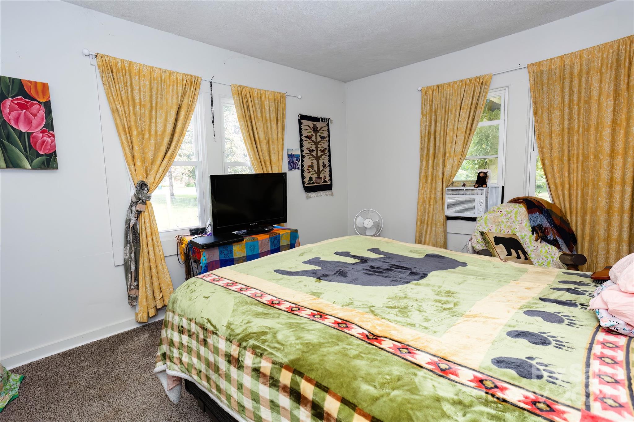 3786 Broad Street Clyde, NC 28721 - Photo 19 of 48 a bedroom with a bed and a flat screen tv