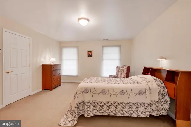 a bedroom with a bed and a refrigerator