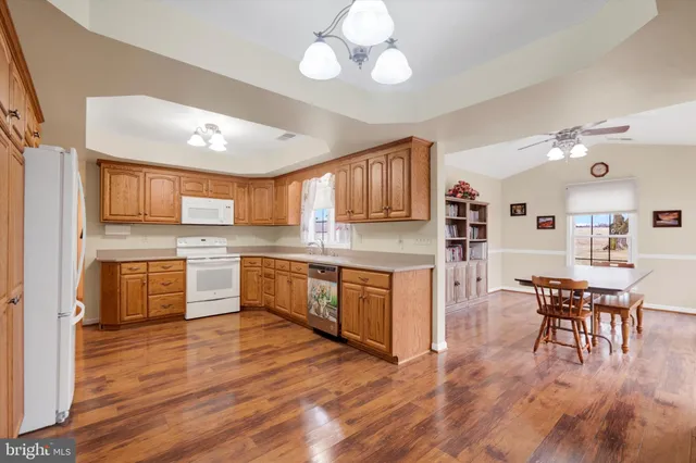 a kitchen with stainless steel appliances granite countertop wooden floors and white cabinets