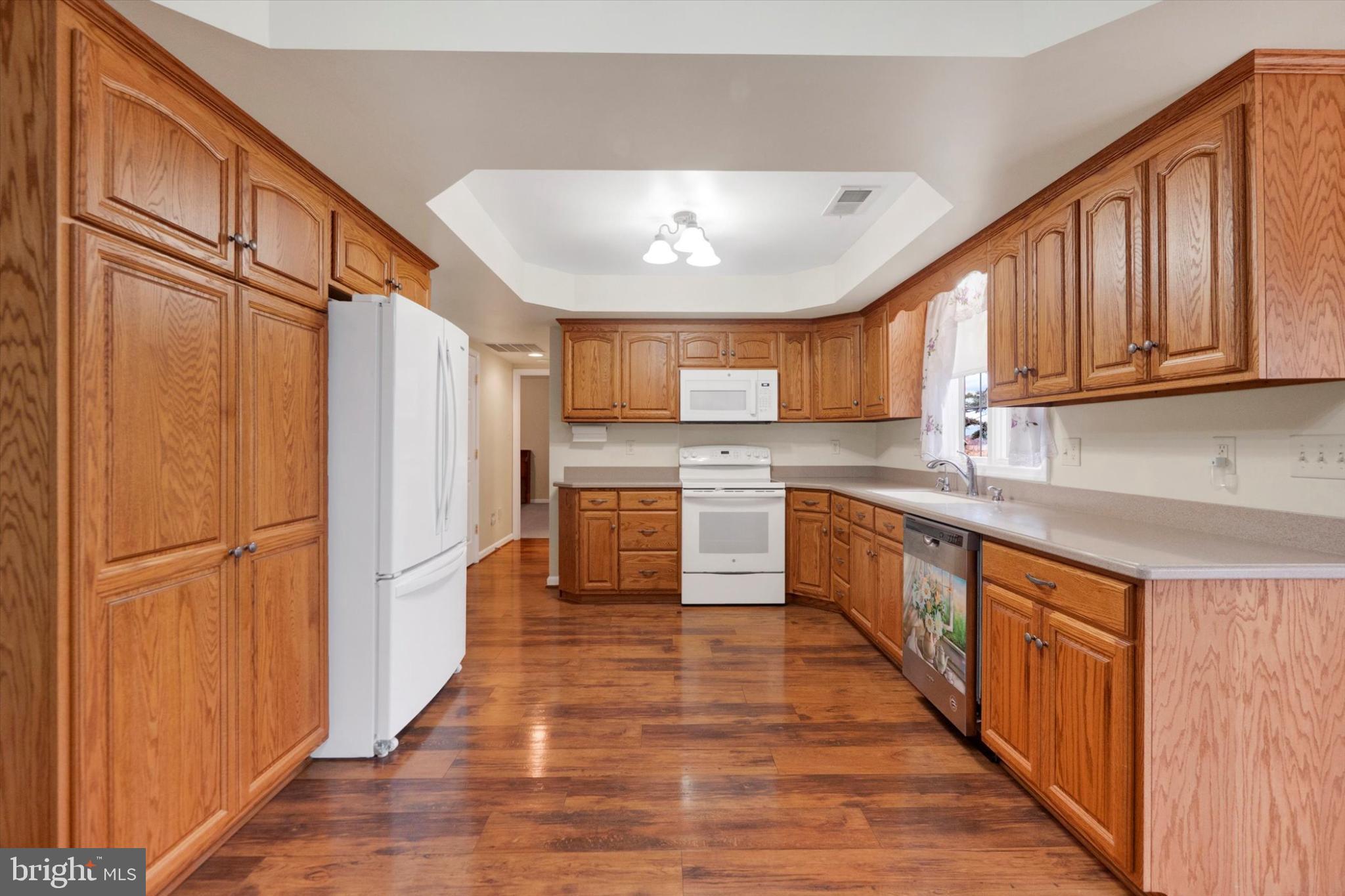 13323 Maugansville Road Hagerstown, MD 21740 - Photo 5 of 27 a kitchen with stainless steel appliances granite countertop a refrigerator a sink dishwasher and a stove with wooden cabinets