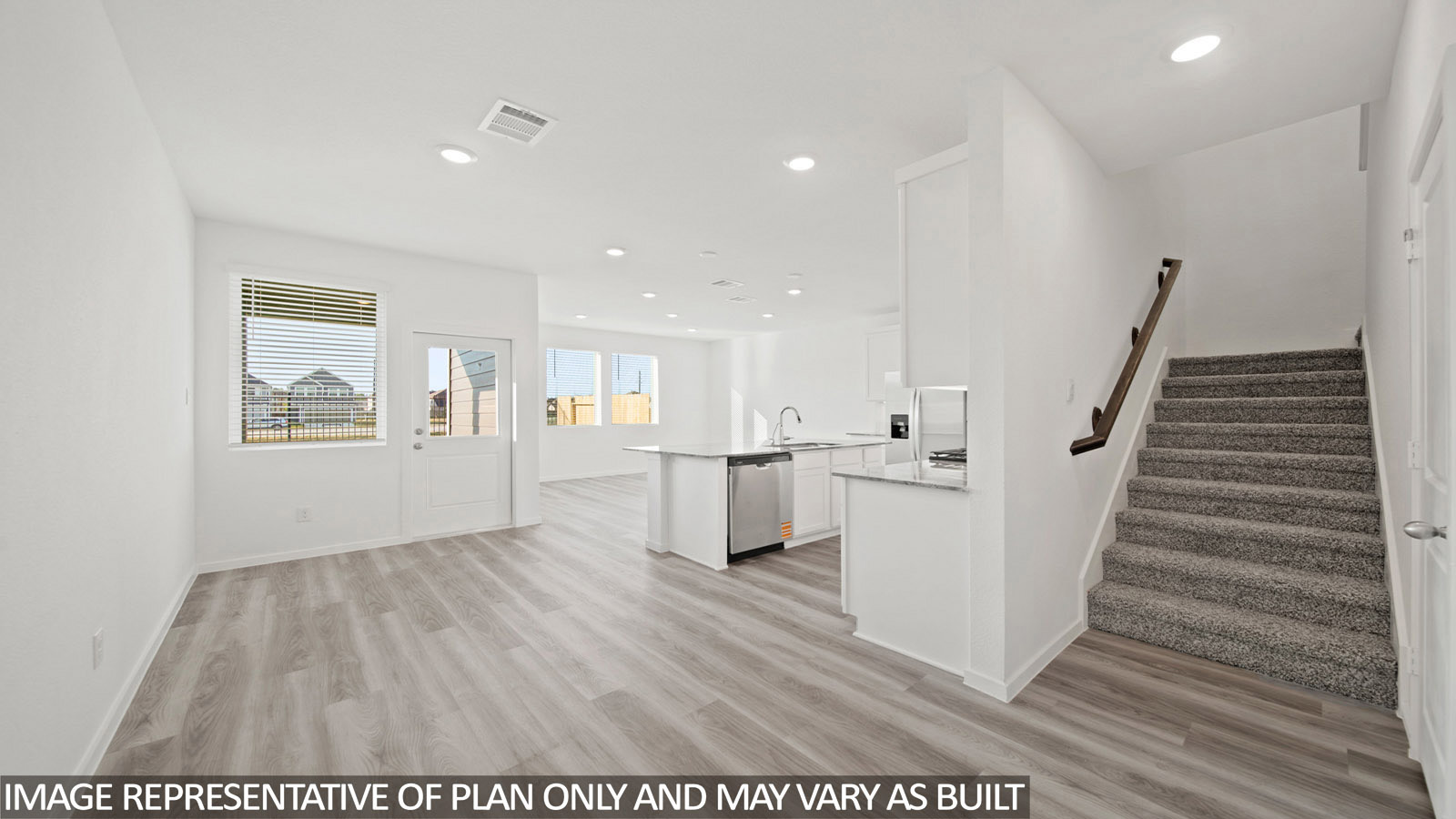 220 Flying Tigers Trail Jarrell, TX 76537 - Photo 5 of 21 Open-concept living space with wood-finish flooring, a contemporary kitchen island, stainless steel appliances, and a carpeted staircase with a wood handrail