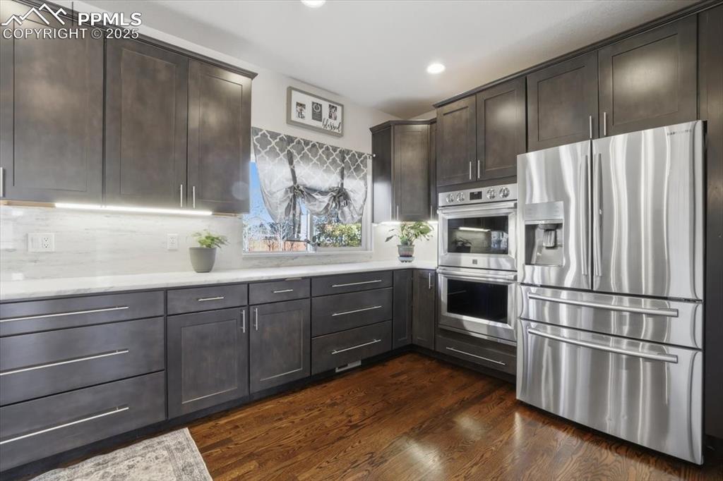 12114 Sleeping Bear Road Peyton, CO 80831 - Photo 11 of 47 a kitchen with stainless steel appliances kitchen island granite countertop a refrigerator and a sink