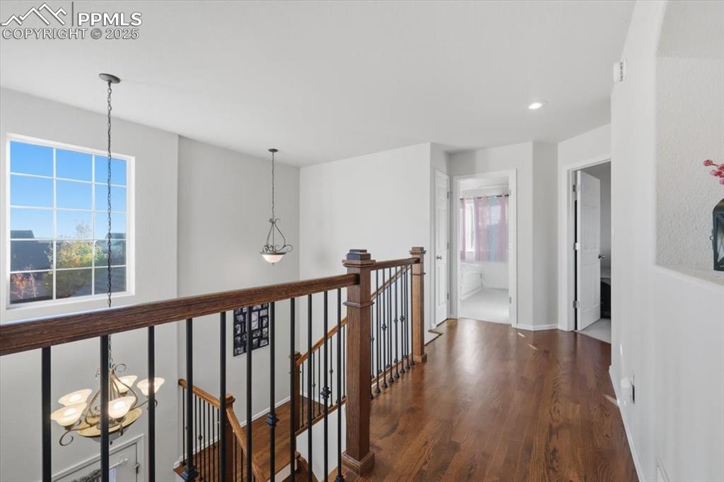 12114 Sleeping Bear Road Peyton, CO 80831 - Photo 18 of 47 a view of a hallway with wooden floor and stairs