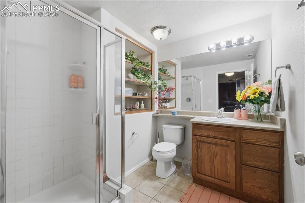 12114 Sleeping Bear Road Peyton, CO 80831 - Photo 37 of 47 a bathroom with a granite countertop sink toilet and shower