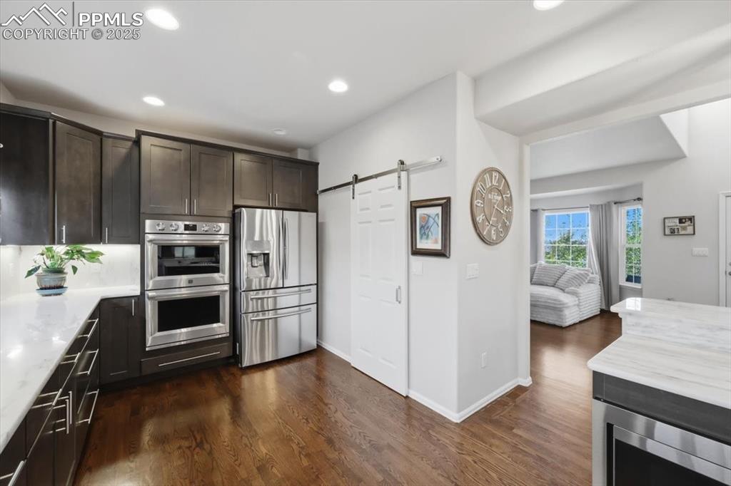 12114 Sleeping Bear Road Peyton, CO 80831 - Photo 10 of 47 a kitchen with granite countertop a refrigerator a stove and a wooden floors