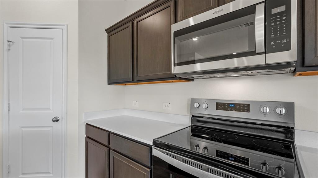 1969 Freeman Street Tyler, TX 75704 - Photo 6 of 30 Kitchen featuring stainless steel appliances, dark wood cabinetry, and light countertops