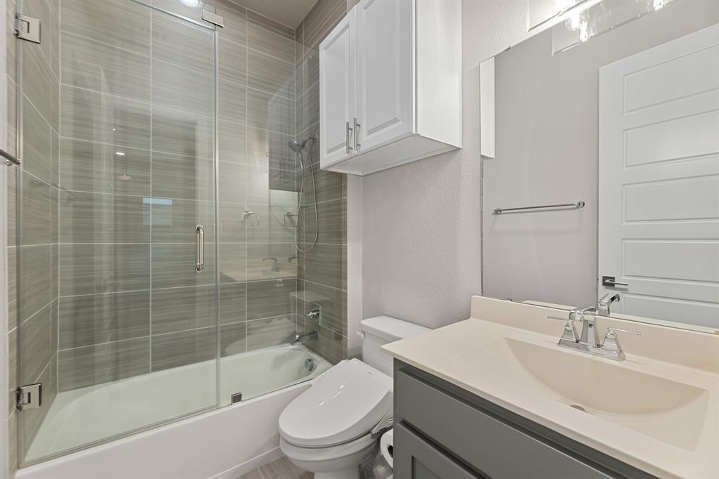 7854 Element Avenue Plano, TX 75024 - Photo 20 of 38 Bathroom with vanity, shower / bath combination with glass door, and a textured wall