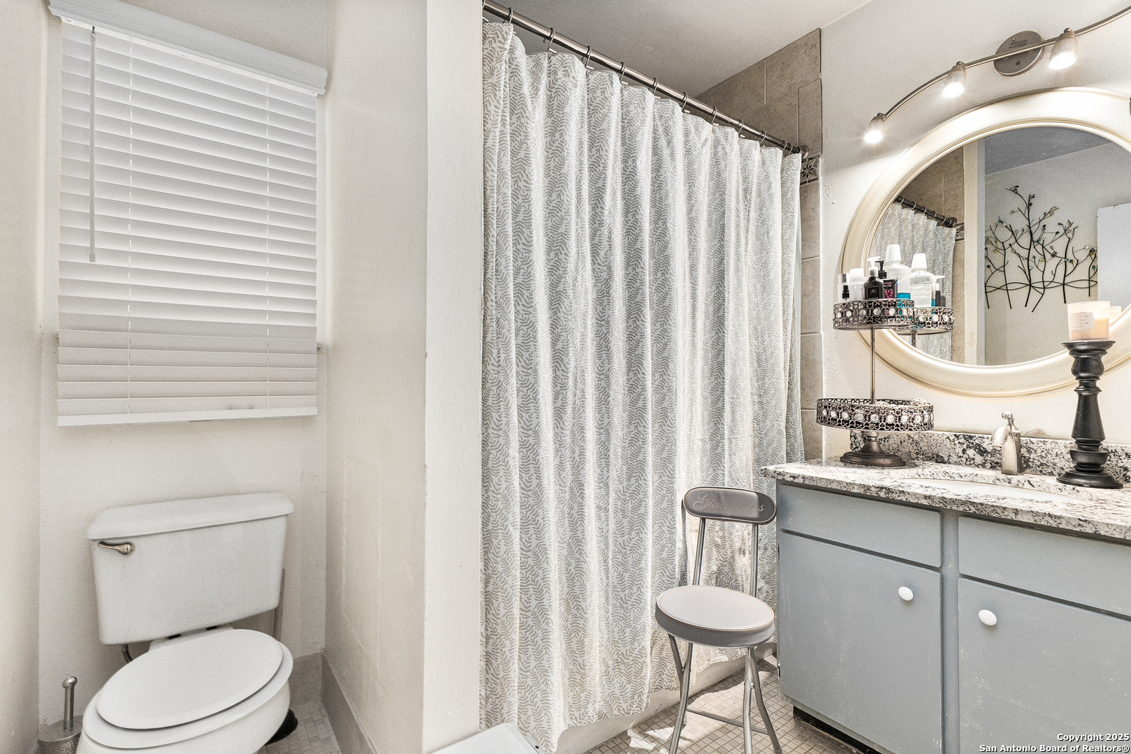 911 Vance Jackson Road, Unit 211 San Antonio, TX 78201 - Photo 6 of 8 a bathroom with a toilet a sink and mirror