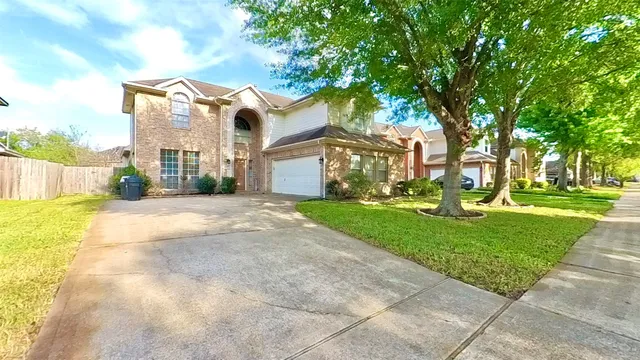 a front view of a house with a yard and fountain