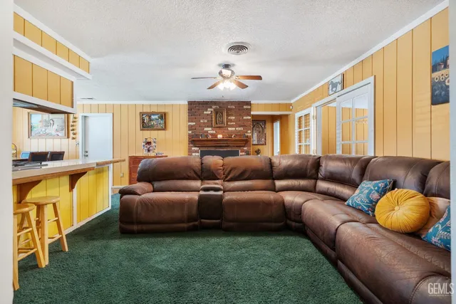 a living room with furniture a fireplace and a kitchen view